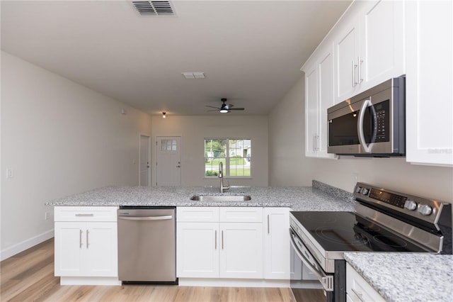 kitchen with white cabinets, sink, light hardwood / wood-style floors, and stainless steel appliances