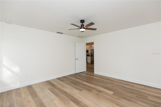 spare room featuring light hardwood / wood-style flooring and ceiling fan