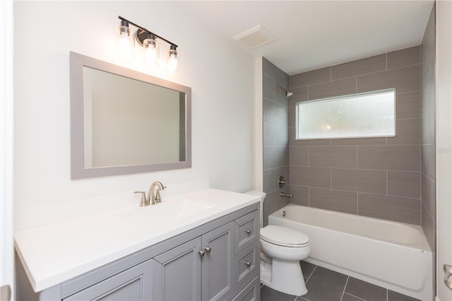 full bathroom with tiled shower / bath, vanity, toilet, and tile patterned flooring