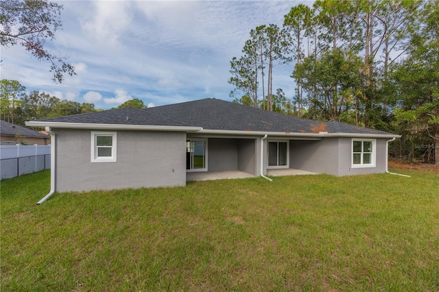 rear view of property featuring a yard and a patio area