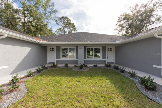 entrance to property featuring a lawn