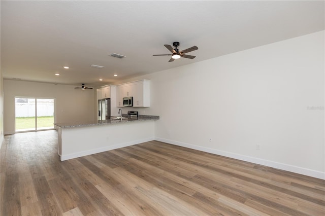 unfurnished living room featuring light wood-type flooring and ceiling fan