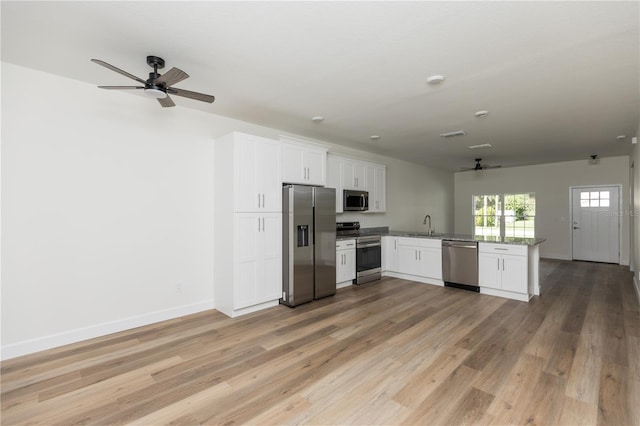 kitchen with white cabinetry, kitchen peninsula, appliances with stainless steel finishes, and light hardwood / wood-style floors