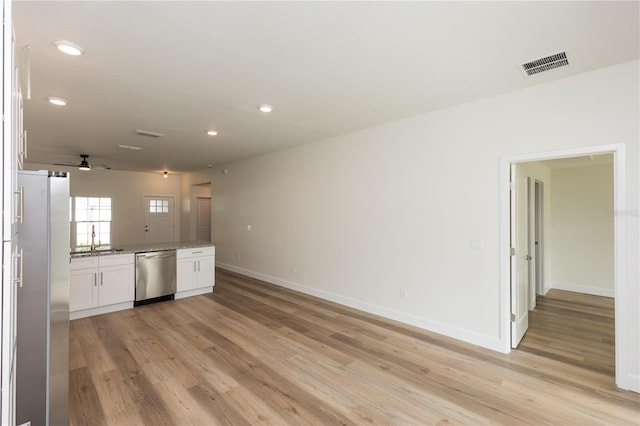 kitchen featuring light hardwood / wood-style floors, white cabinets, stone counters, stainless steel dishwasher, and fridge