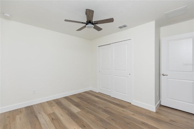 unfurnished bedroom featuring a closet, light hardwood / wood-style floors, and ceiling fan