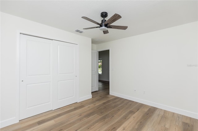 unfurnished bedroom featuring wood-type flooring, ceiling fan, and a closet