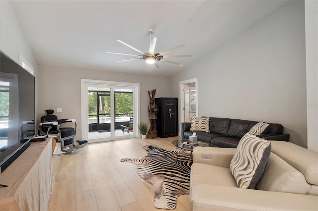 living room with vaulted ceiling, ceiling fan, and light wood-type flooring