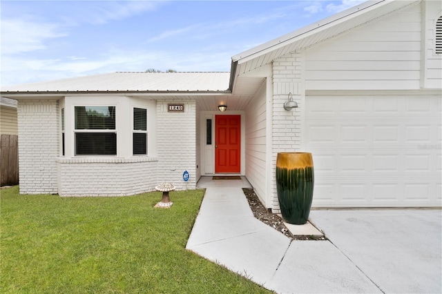 property entrance featuring a yard and a garage