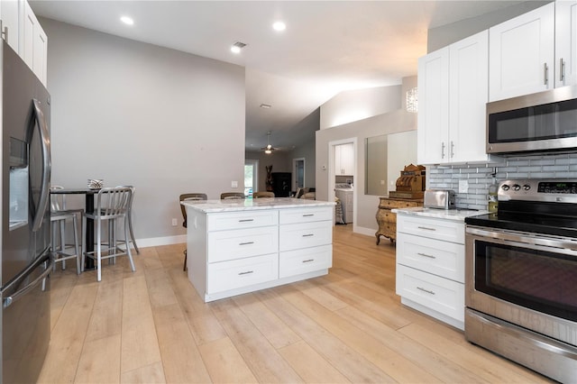 kitchen featuring white cabinets, appliances with stainless steel finishes, light hardwood / wood-style floors, and ceiling fan