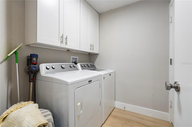 washroom featuring hookup for a washing machine, light hardwood / wood-style flooring, cabinets, and washer and clothes dryer