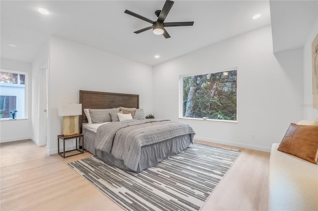 bedroom featuring multiple windows, light hardwood / wood-style floors, and ceiling fan