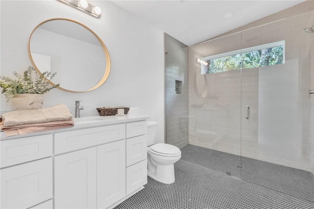 bathroom with tile patterned flooring, vanity, toilet, and an enclosed shower