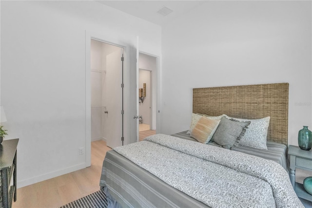 bedroom featuring a closet, light hardwood / wood-style floors, and a spacious closet