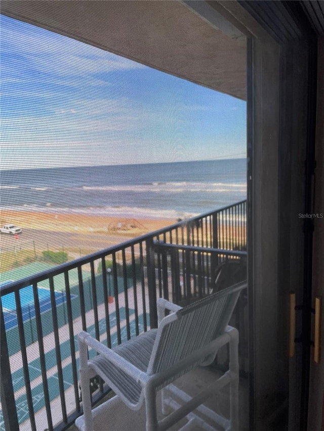 balcony with a water view and a beach view