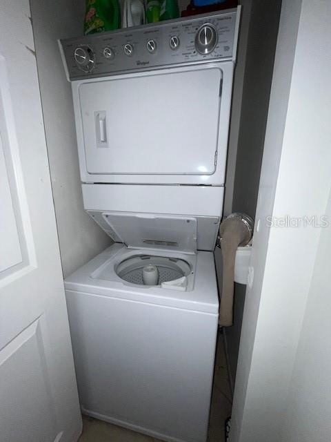 washroom featuring stacked washer and clothes dryer