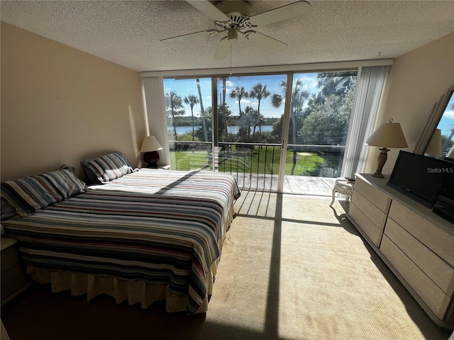 bedroom featuring multiple windows, ceiling fan, light colored carpet, and a textured ceiling