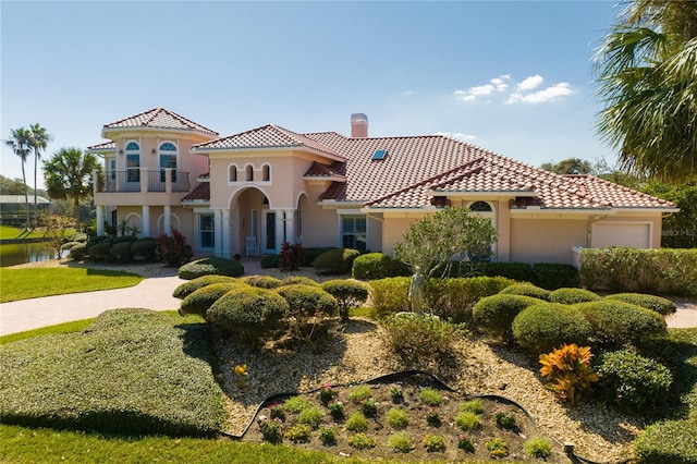 mediterranean / spanish home with a balcony and a front yard