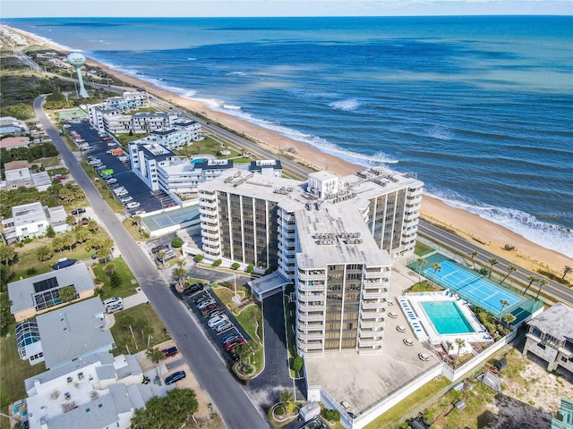 drone / aerial view featuring a water view and a view of the beach