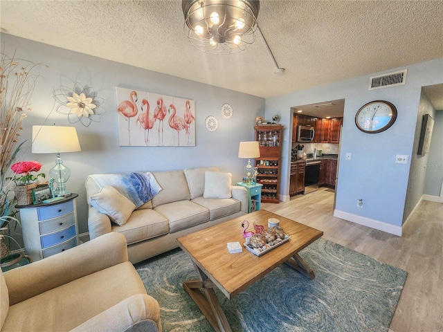 living room featuring light hardwood / wood-style flooring and a textured ceiling