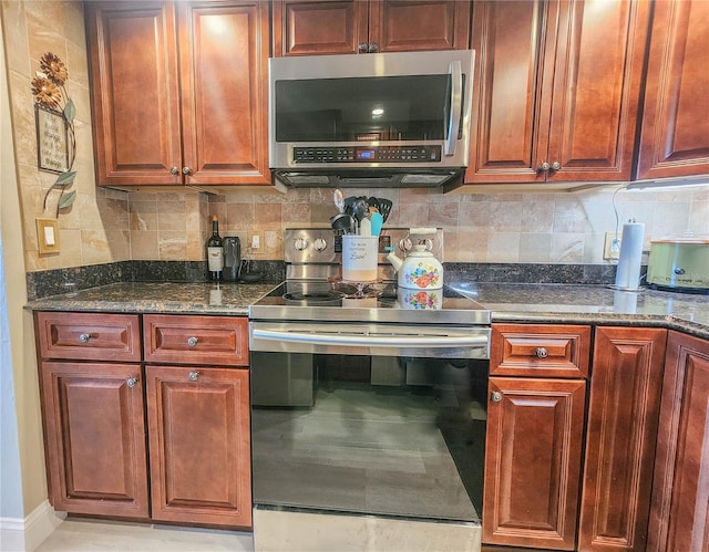 kitchen featuring tasteful backsplash, electric range oven, and dark stone counters