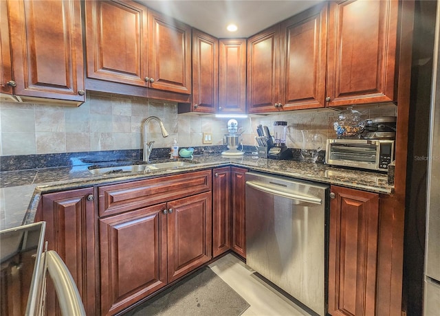 kitchen with stainless steel dishwasher, light tile floors, backsplash, dark stone countertops, and sink