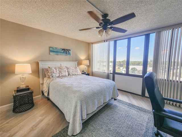 bedroom featuring a textured ceiling, ceiling fan, and light wood-type flooring