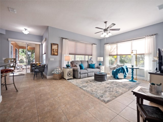 living room featuring light tile floors and ceiling fan