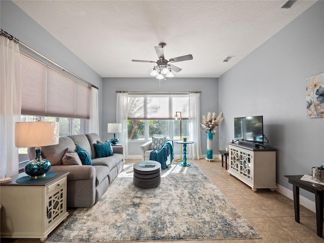 tiled living room featuring a textured ceiling and ceiling fan