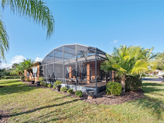 exterior space featuring glass enclosure and a yard