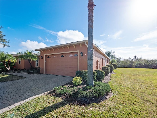 view of side of home featuring a garage and a yard