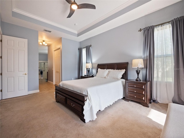 bedroom featuring a closet, a tray ceiling, ceiling fan, and light colored carpet