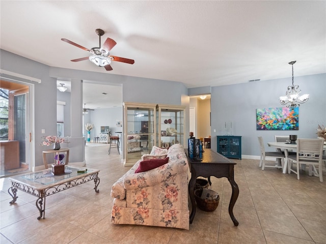 tiled living room with ceiling fan with notable chandelier