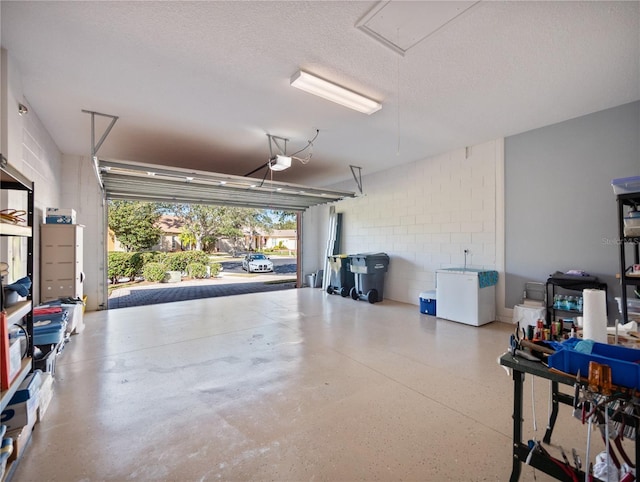 garage with a garage door opener and concrete block wall