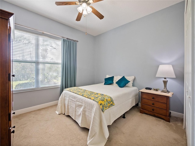 bedroom featuring baseboards, a ceiling fan, and light colored carpet