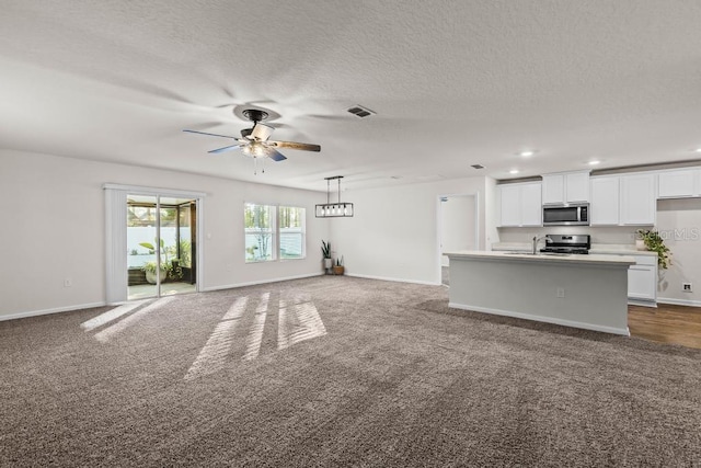 unfurnished living room with carpet flooring, a textured ceiling, and ceiling fan with notable chandelier