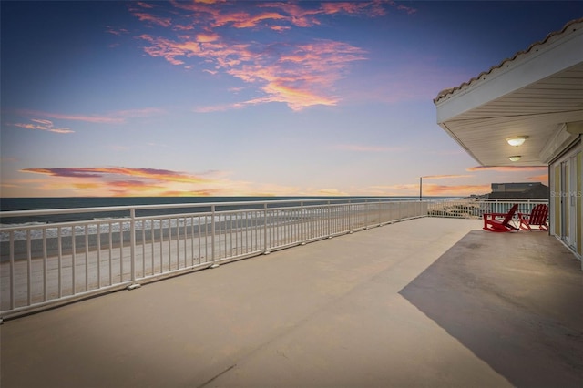 patio terrace at dusk featuring a balcony