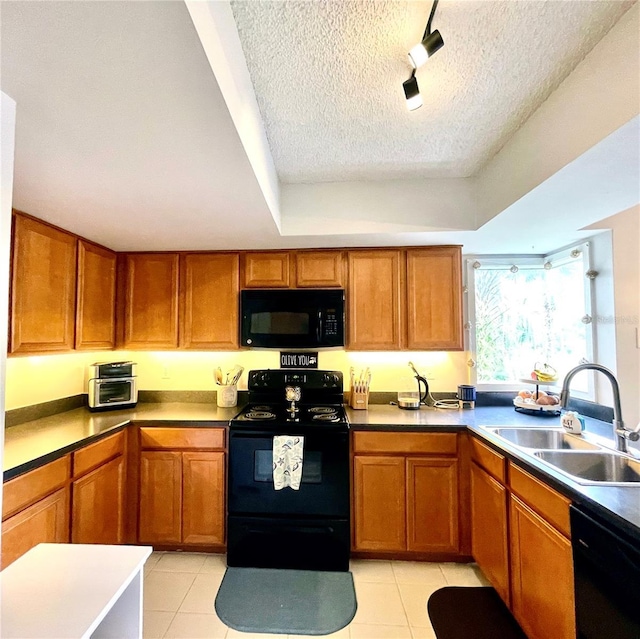 kitchen featuring black appliances, brown cabinets, and a sink