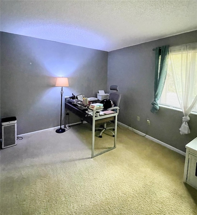 home office with a textured ceiling, carpet, and baseboards