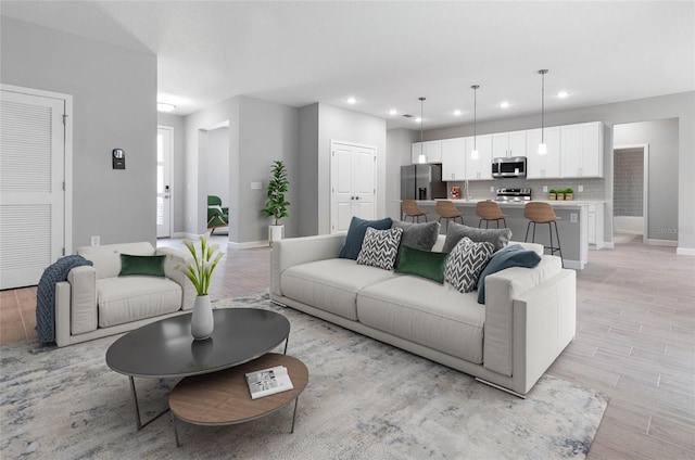 living area featuring recessed lighting, baseboards, and light wood-style floors