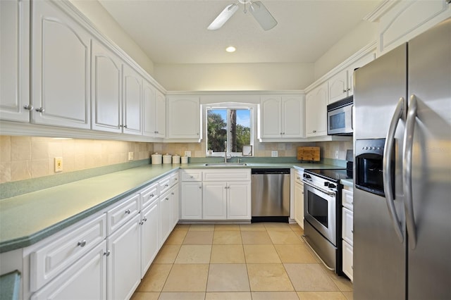 kitchen with stainless steel appliances, light tile flooring, ceiling fan, white cabinets, and backsplash