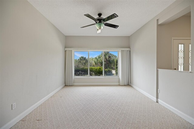 carpeted empty room featuring ceiling fan and a textured ceiling