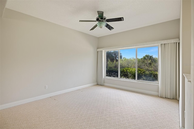 spare room featuring a textured ceiling, light colored carpet, and ceiling fan