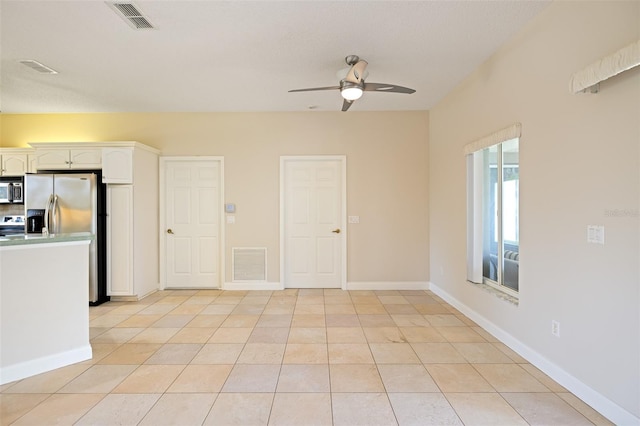 tiled spare room with ceiling fan