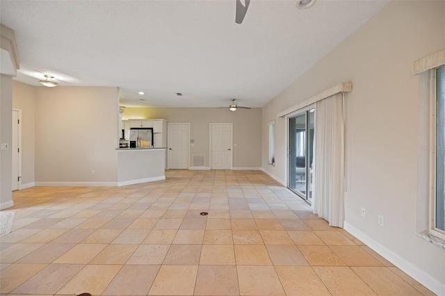 unfurnished living room with ceiling fan and light tile floors