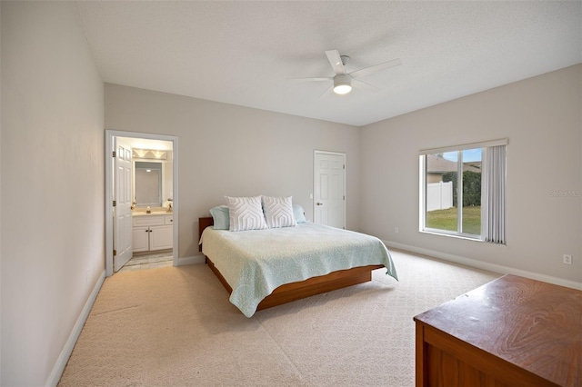 carpeted bedroom featuring ensuite bath and ceiling fan