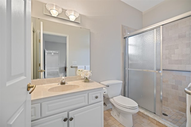 bathroom featuring toilet, vanity with extensive cabinet space, tile flooring, and an enclosed shower