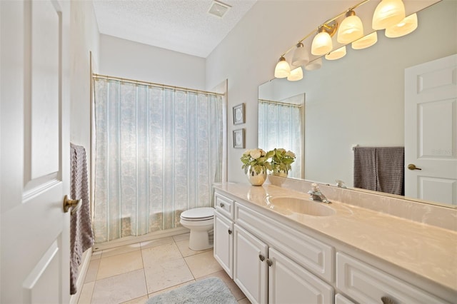 bathroom with large vanity, tile flooring, toilet, and a textured ceiling