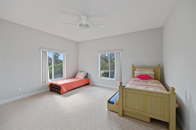 bedroom featuring multiple windows, ceiling fan, and light colored carpet