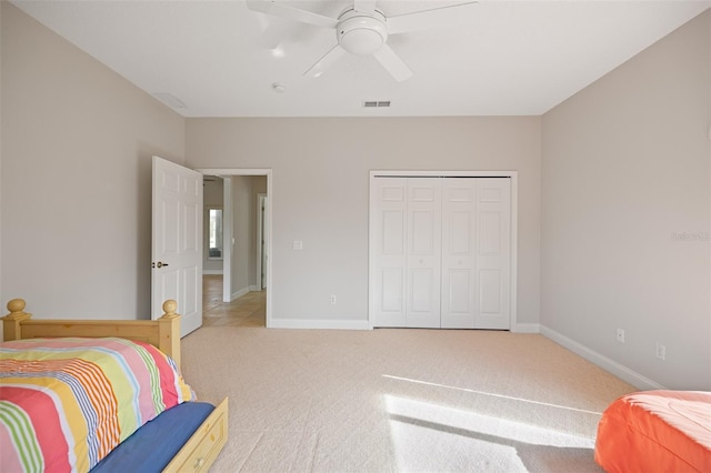 carpeted bedroom featuring a closet and ceiling fan