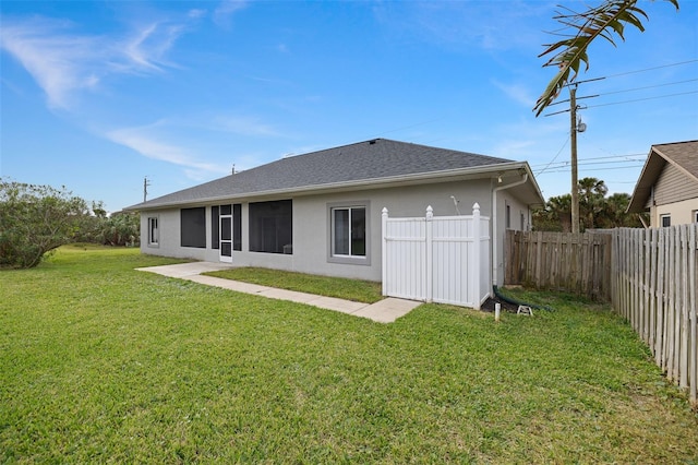 rear view of house featuring a yard